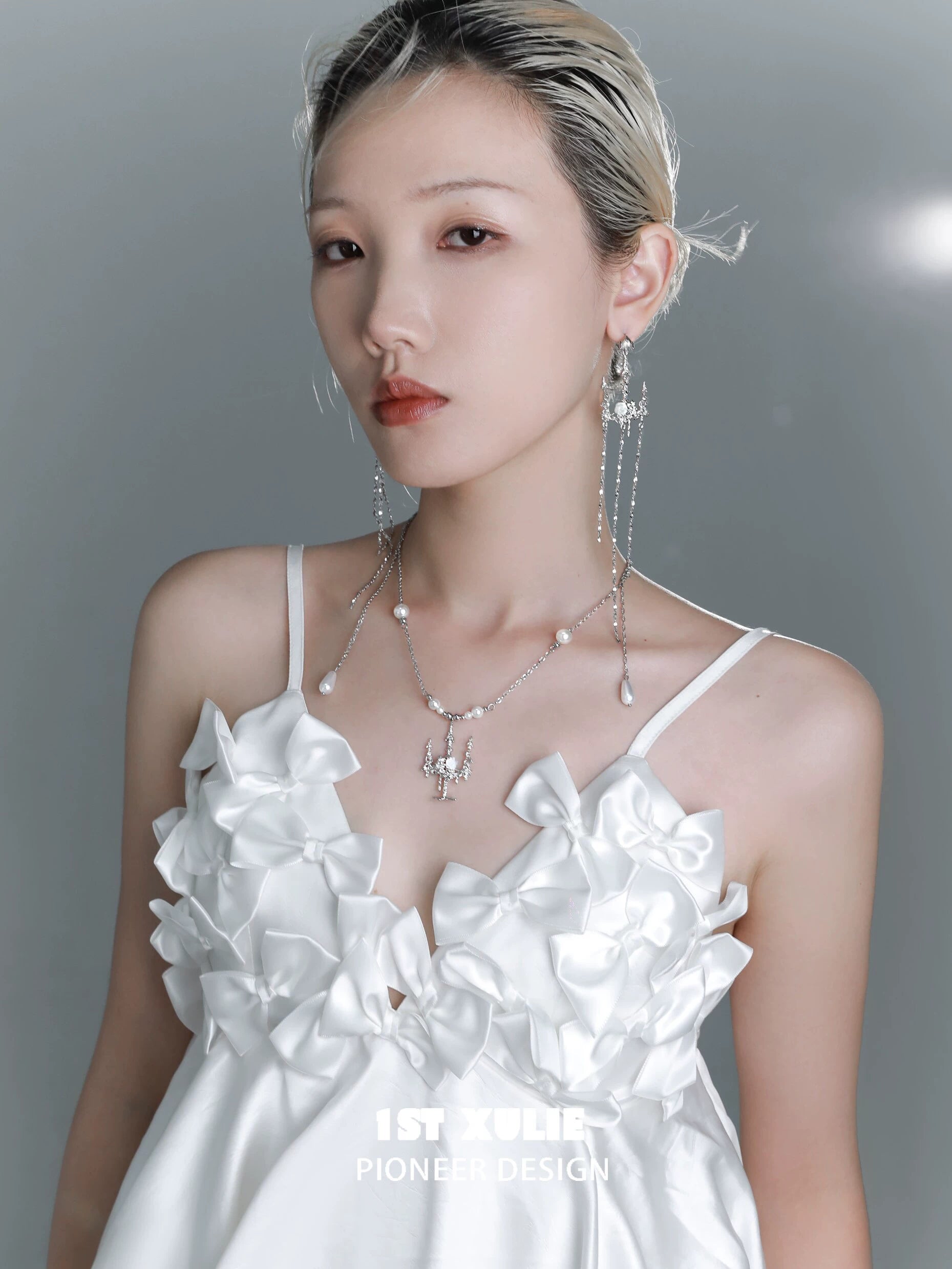 Elegant model wearing a pearl clavicle necklace paired with a white ruffled dress