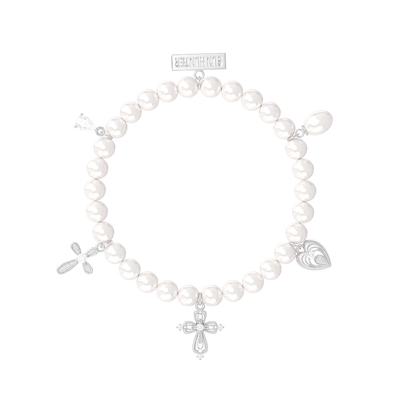 Elegant pearl cross bracelet featuring silver charms for a stylish accessory look