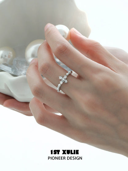 Elegant pearl cross silver ring showcased on a hand holding decorative pearls