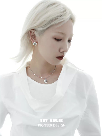Elegant model wearing a pearl statement necklace paired with a white blouse for a chic look