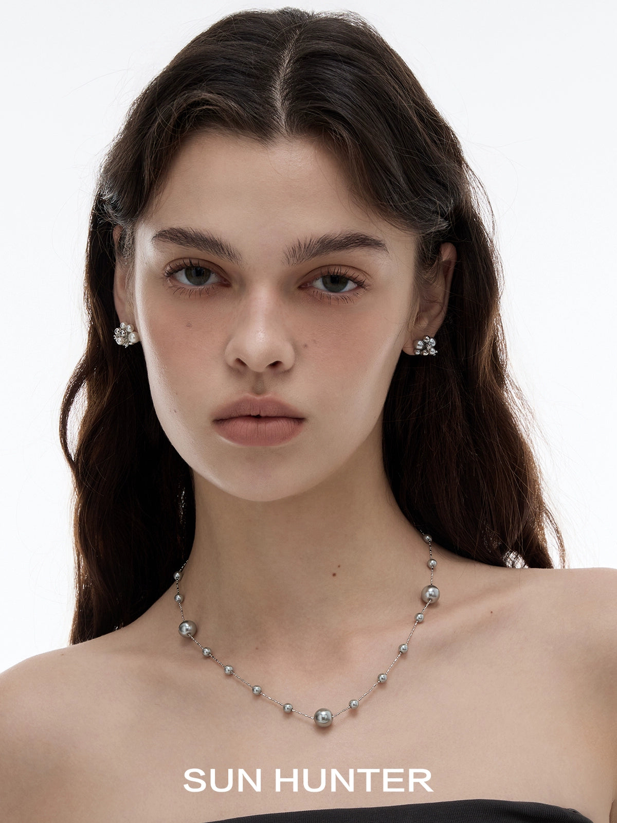 SUN HUNTER pearl zircon statement earrings featured on a model with a sleek hairstyle