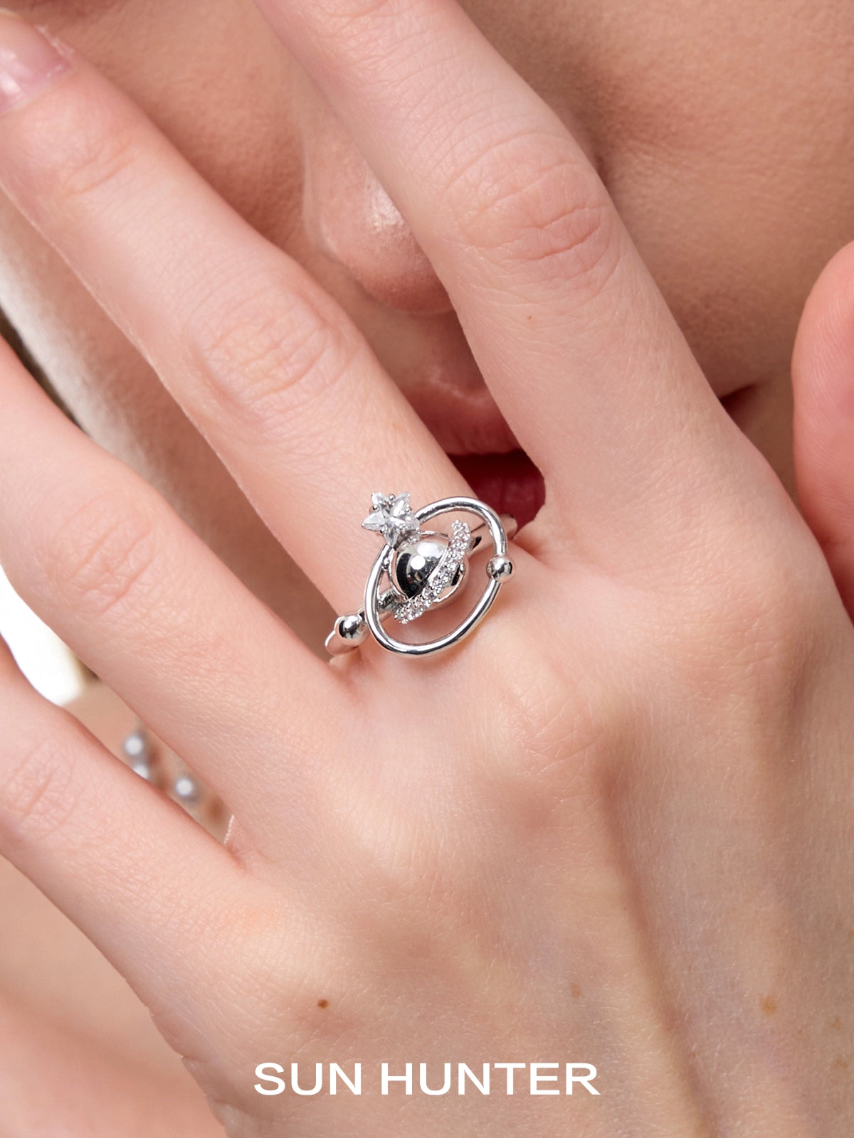 SUN HUNTER planet garden ring featuring a celestial design with sparkling accents on a silver band