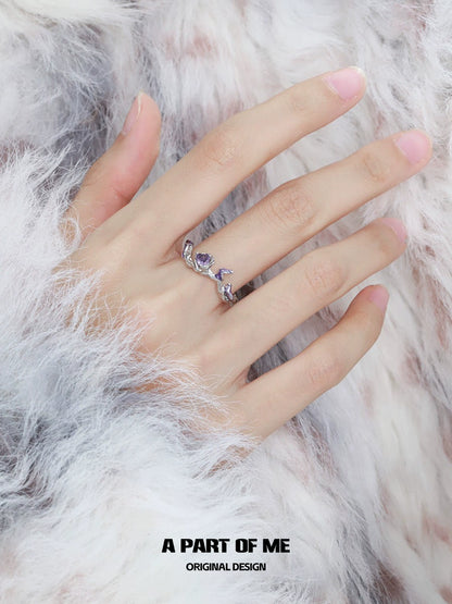 A sparkling purple rose goddess ring elegantly set on a hand wearing a fluffy white coat