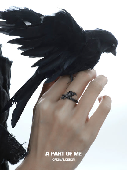 A PART OF ME raven gothic ring worn on a hand with a black bird perched on it