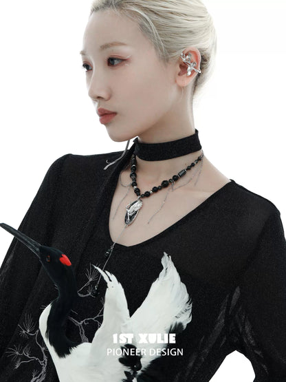 Rebellious crane tassel necklace showcased on model with black choker and intricate design details