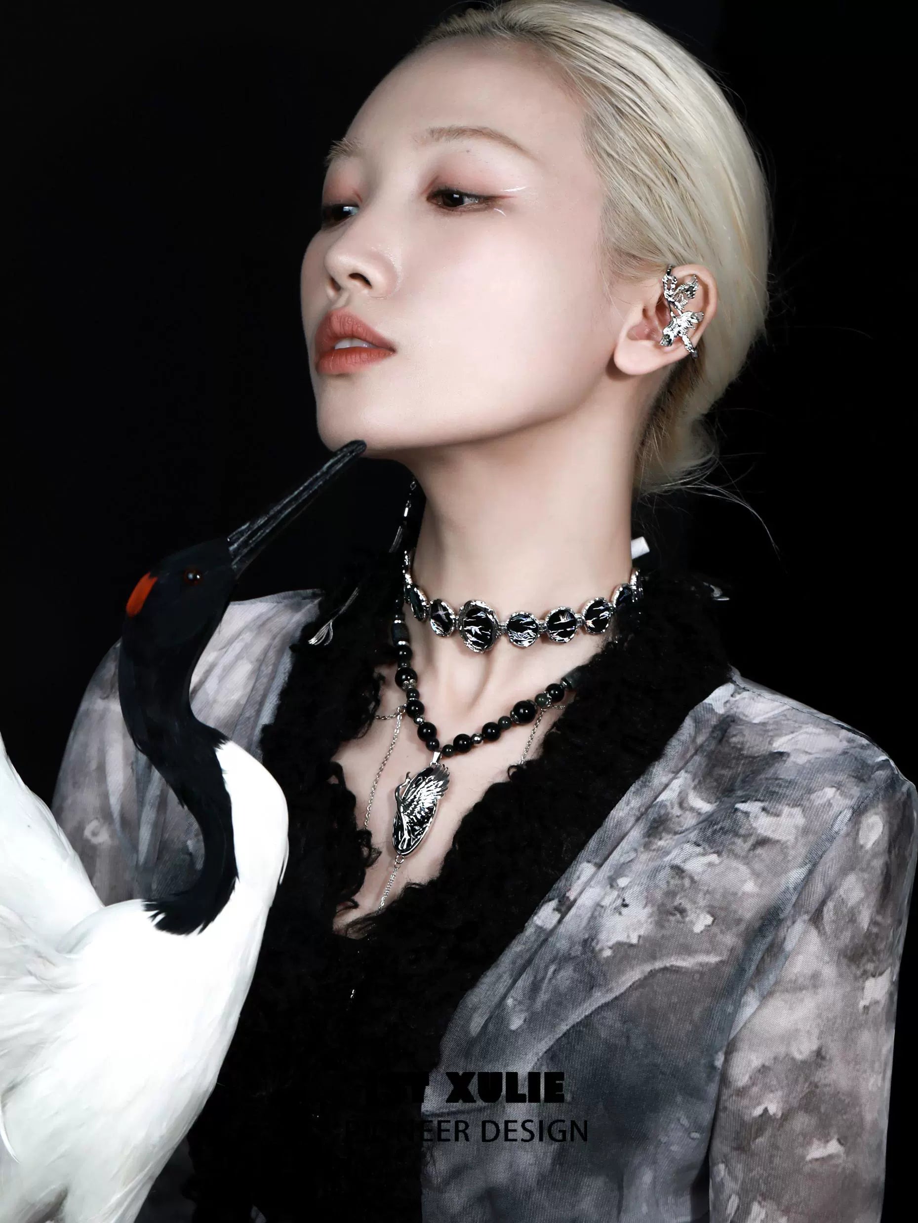 Elegant model wearing a rebellious crane tassel necklace, styled with unique accessories and a black outfit