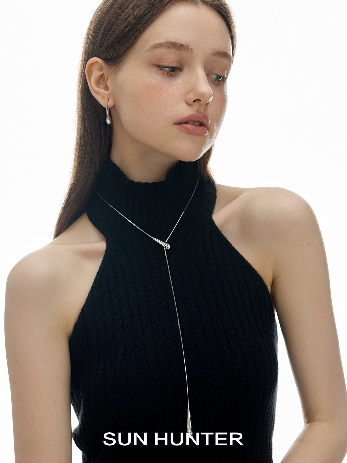 Stylish model wearing SUN HUNTER retro metal water drop earrings with a chic halter neck top