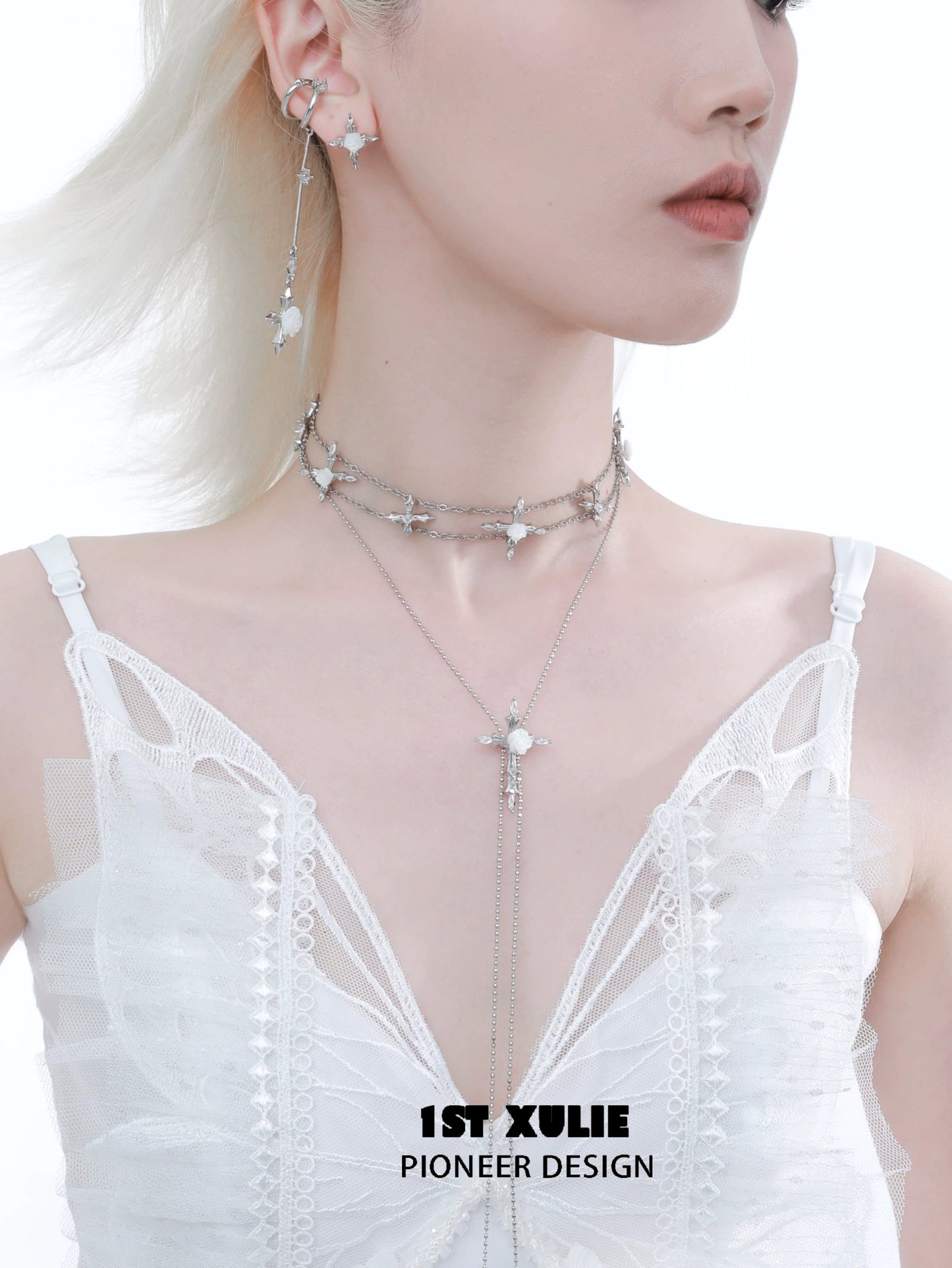 Elegant model wearing a rose cross necklace layered with silver chains and star charms
