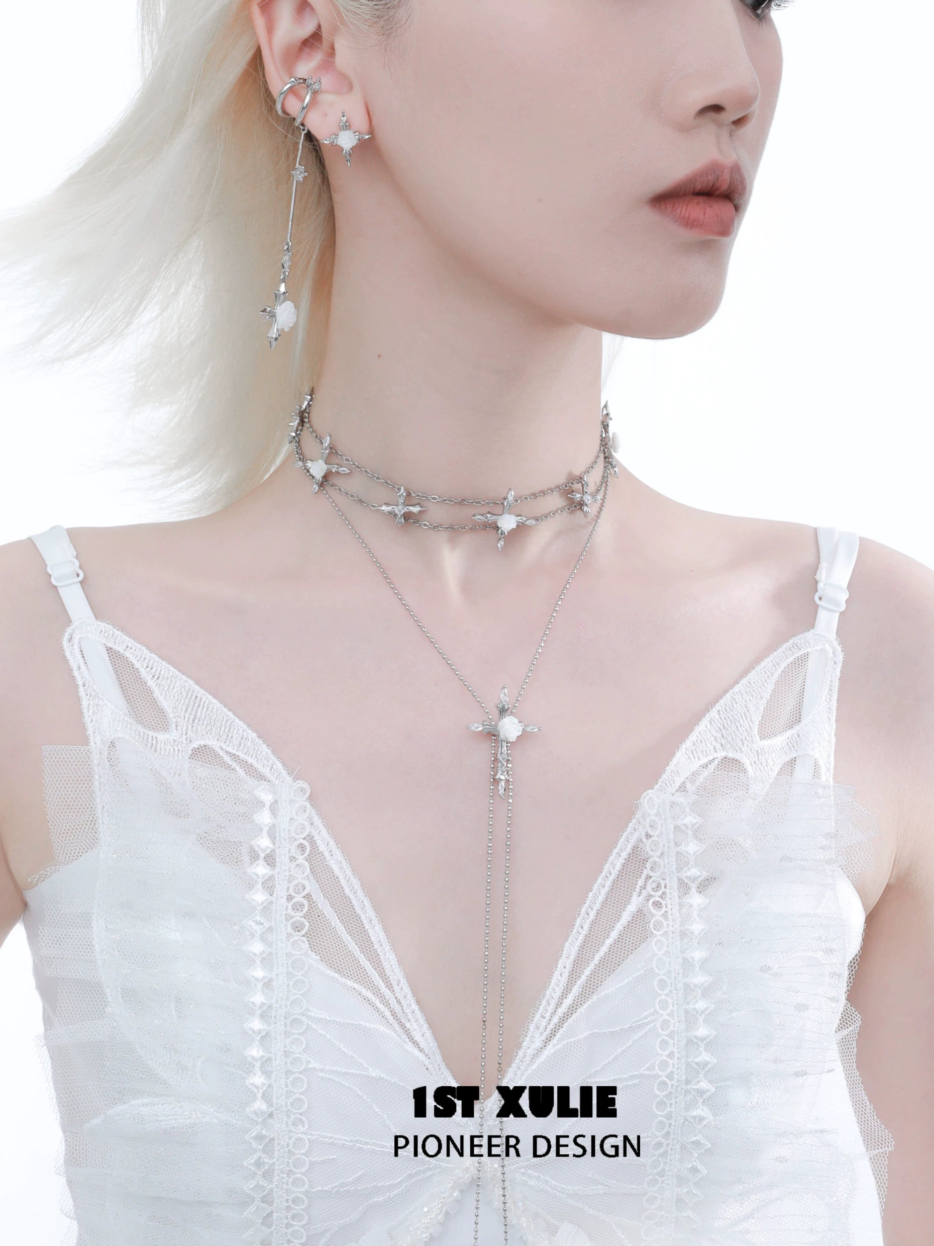 Elegant model wearing a rose cross necklace layered with silver chains and star charms