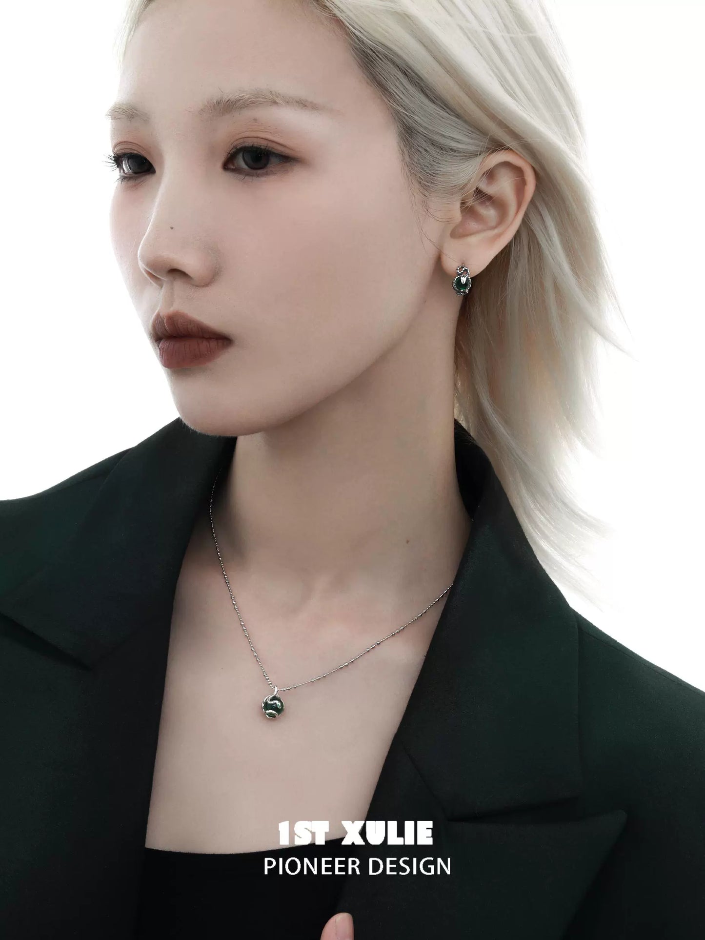 Serpent silver necklace paired with elegant earrings, worn by a model in a stylish outfit