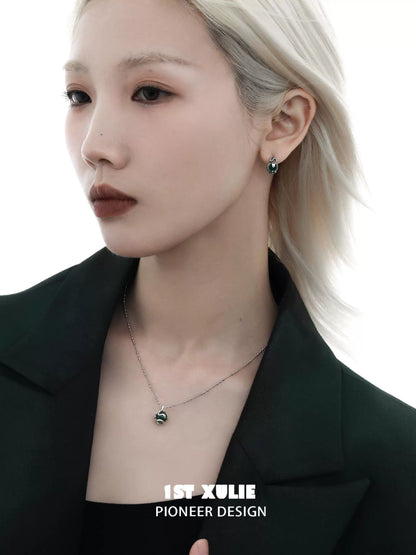 Serpent silver necklace paired with elegant earrings, worn by a model in a stylish outfit