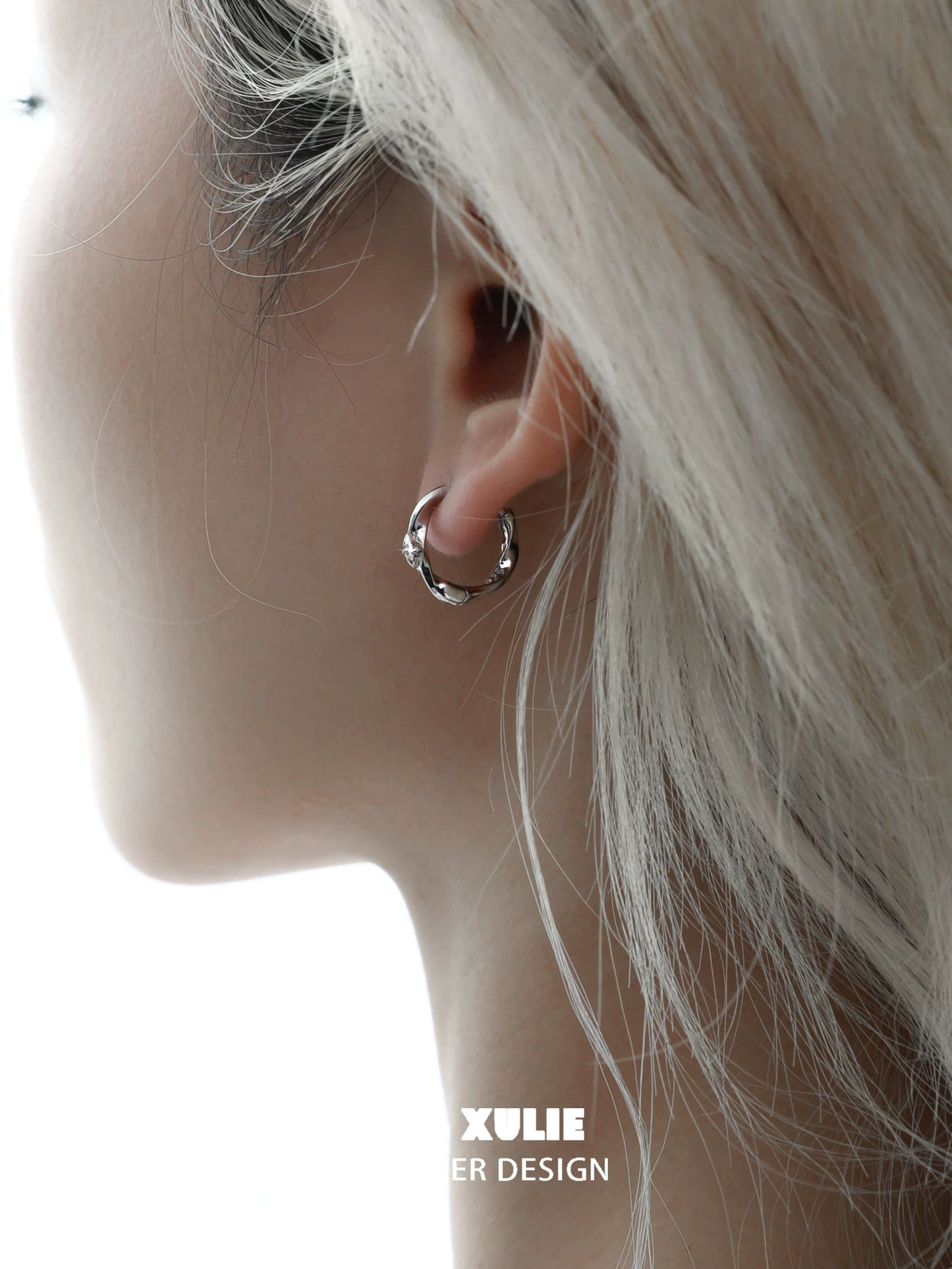 Elegant shooting star silver earrings showcased on a model's ear for a stylish look