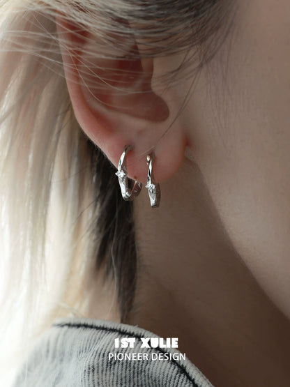 Shooting star silver earrings displayed on an ear with a modern design for stylish elegance