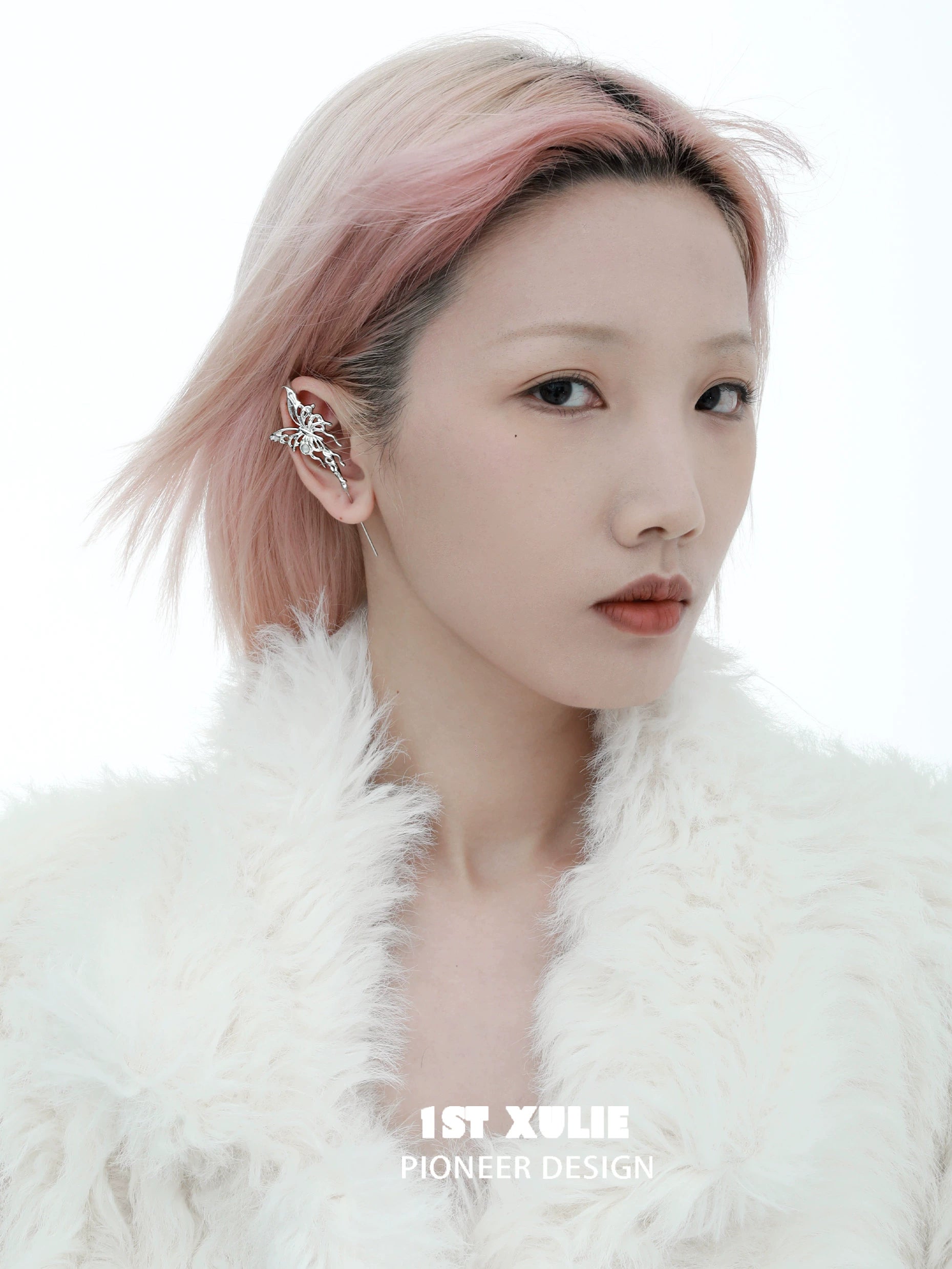 Model wearing a silver butterfly piercing earring with a stylish white fur coat