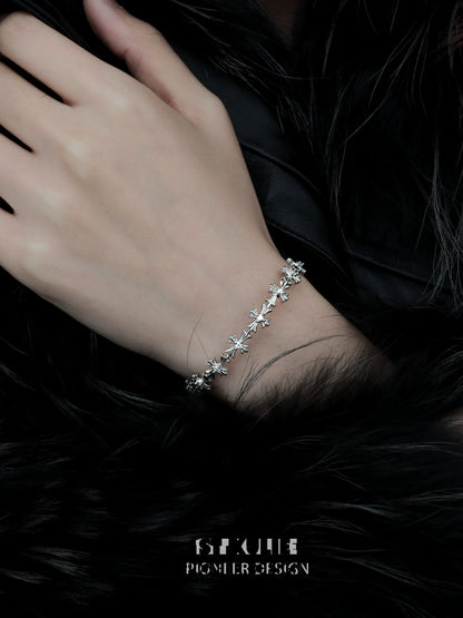 Elegant silver cross bracelet delicately worn on a hand against a dark fur background