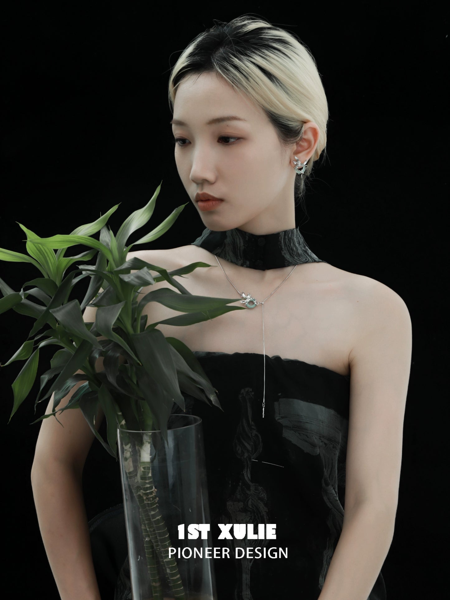 Elegant silver iris pull buckle necklace worn with a black dress, featuring a sleek design