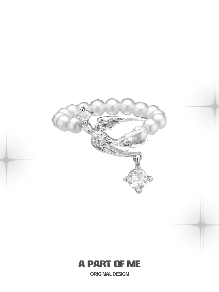 Unique silver pearl ring featuring a twisted design and a sparkling charm for elegant style