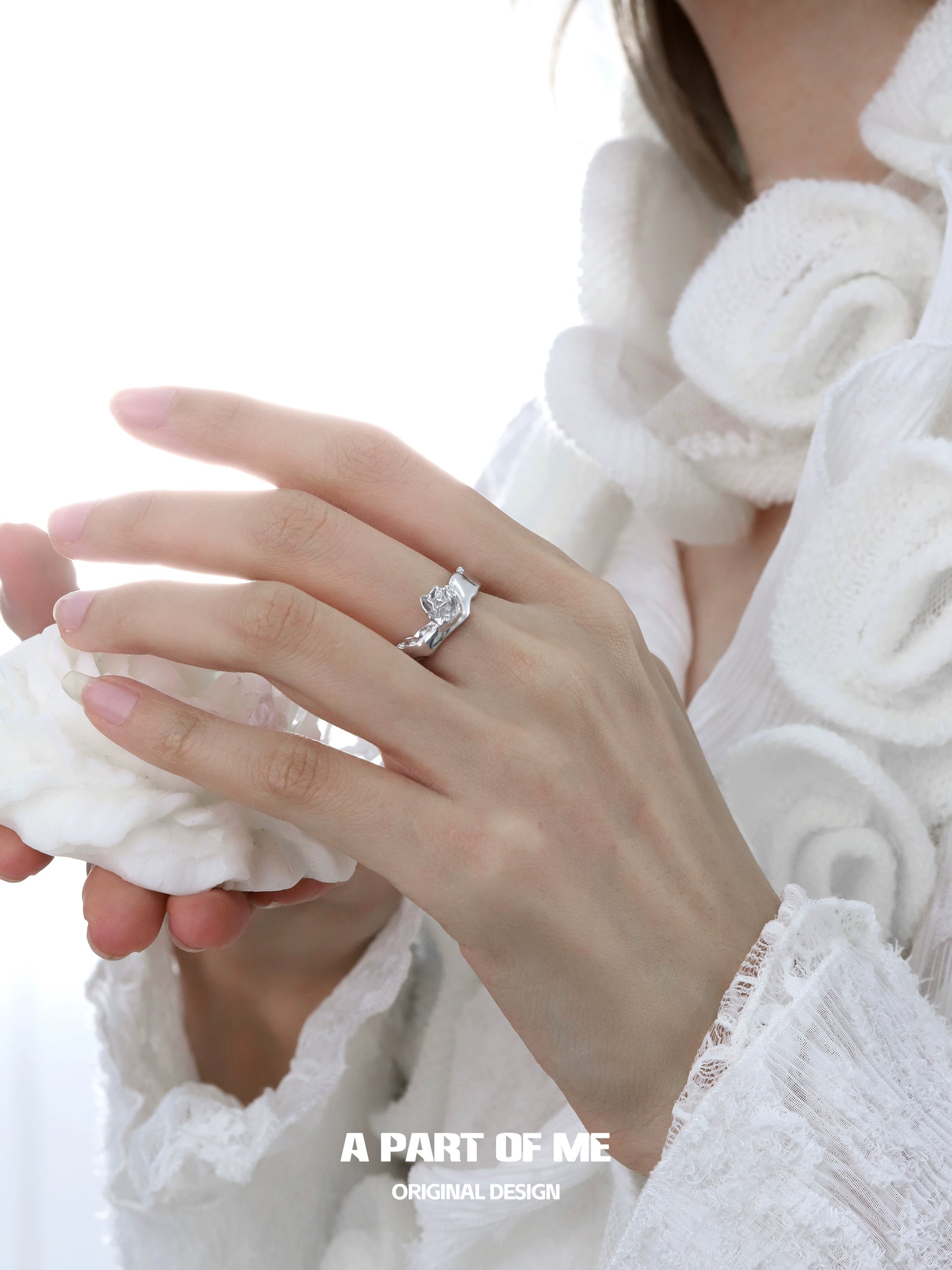 A Part of Me silver rose ring displayed on a woman's hand with elegant design features