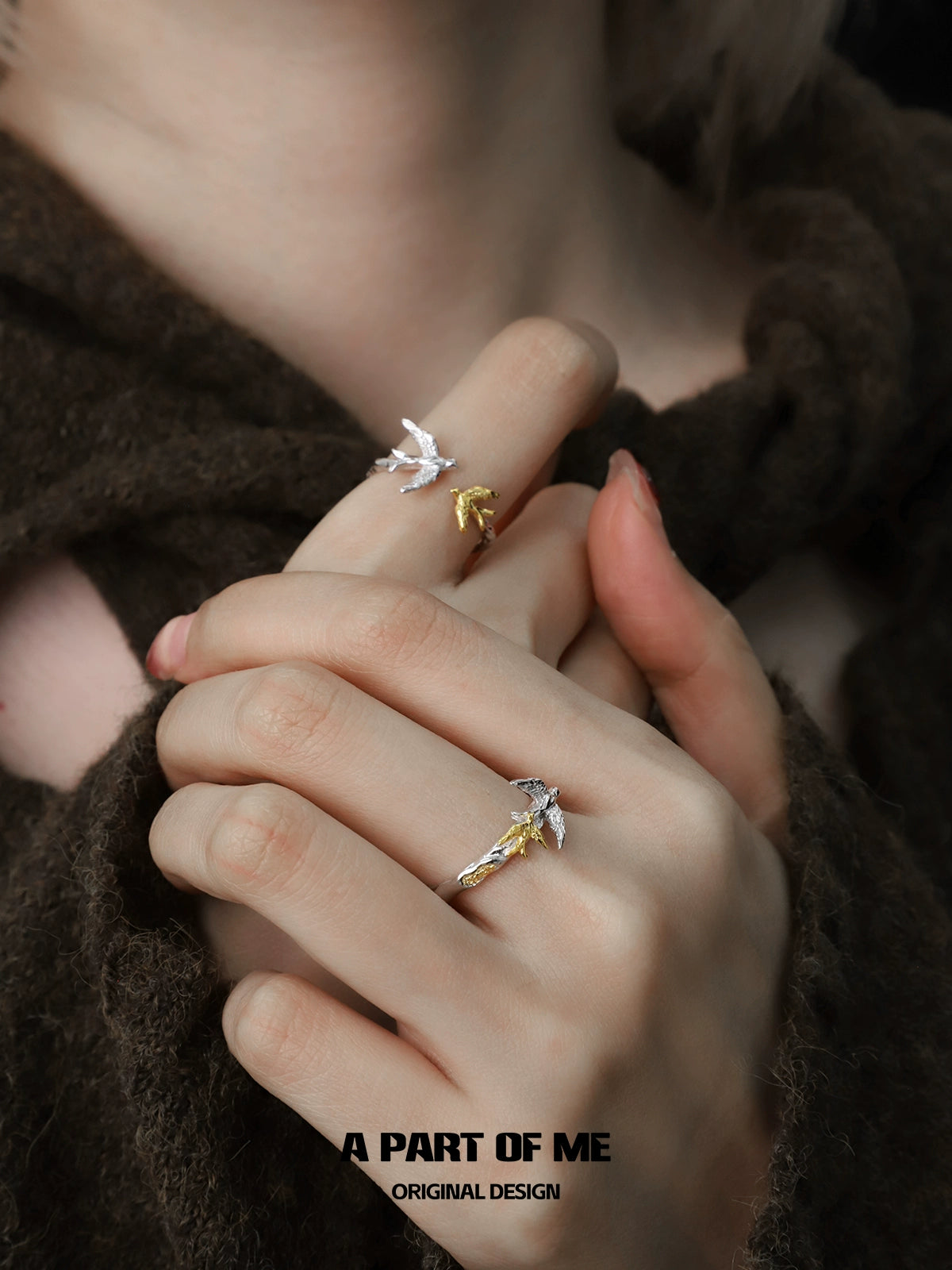 Soaring birds ring in silver and gold, showcasing a delicate design on styled hands