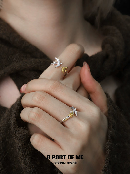 Soaring birds ring in silver and gold, showcasing a delicate design on styled hands