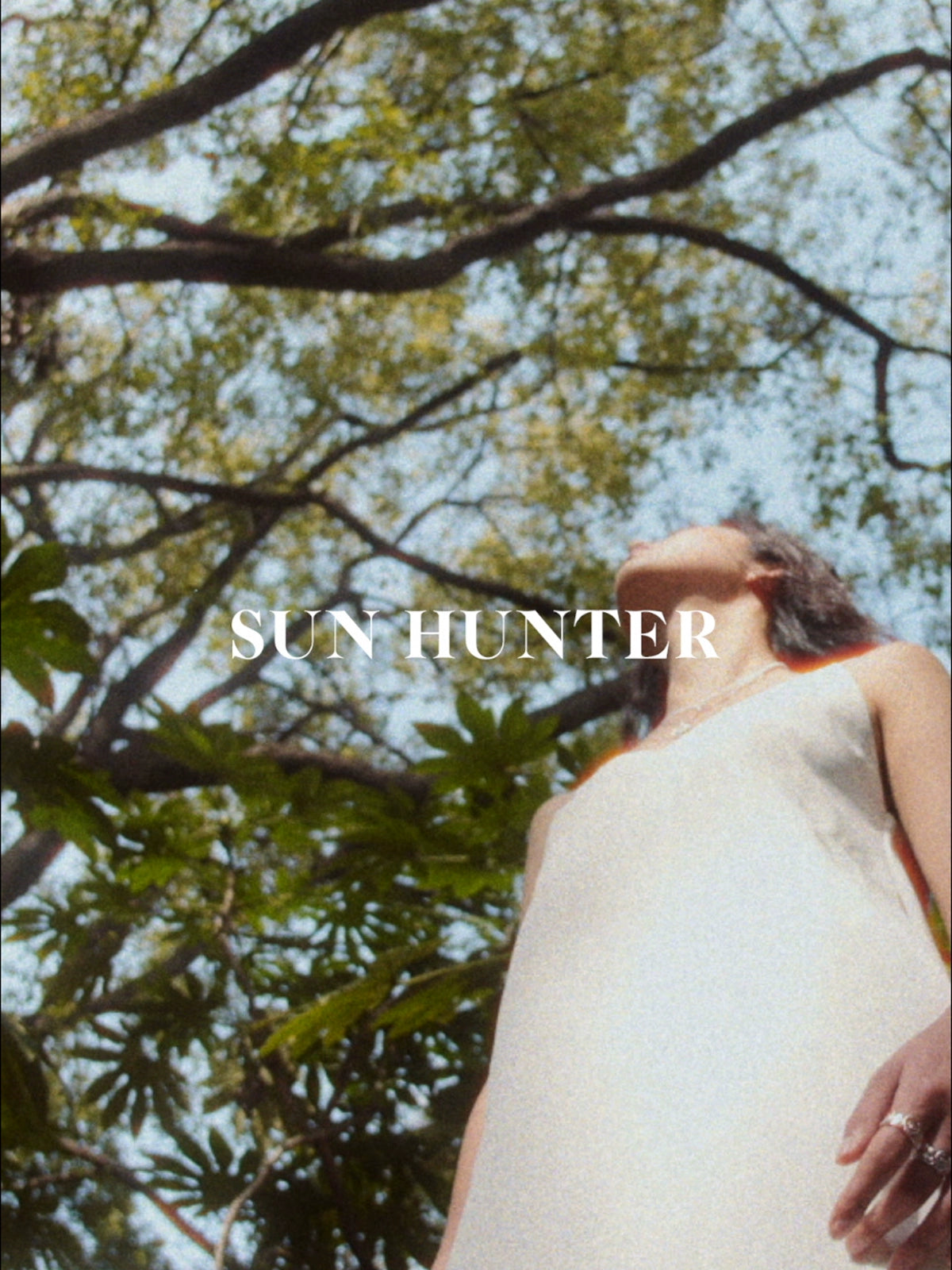 Model showcasing SUN HUNTER spring lace keychain earrings in a natural outdoor setting