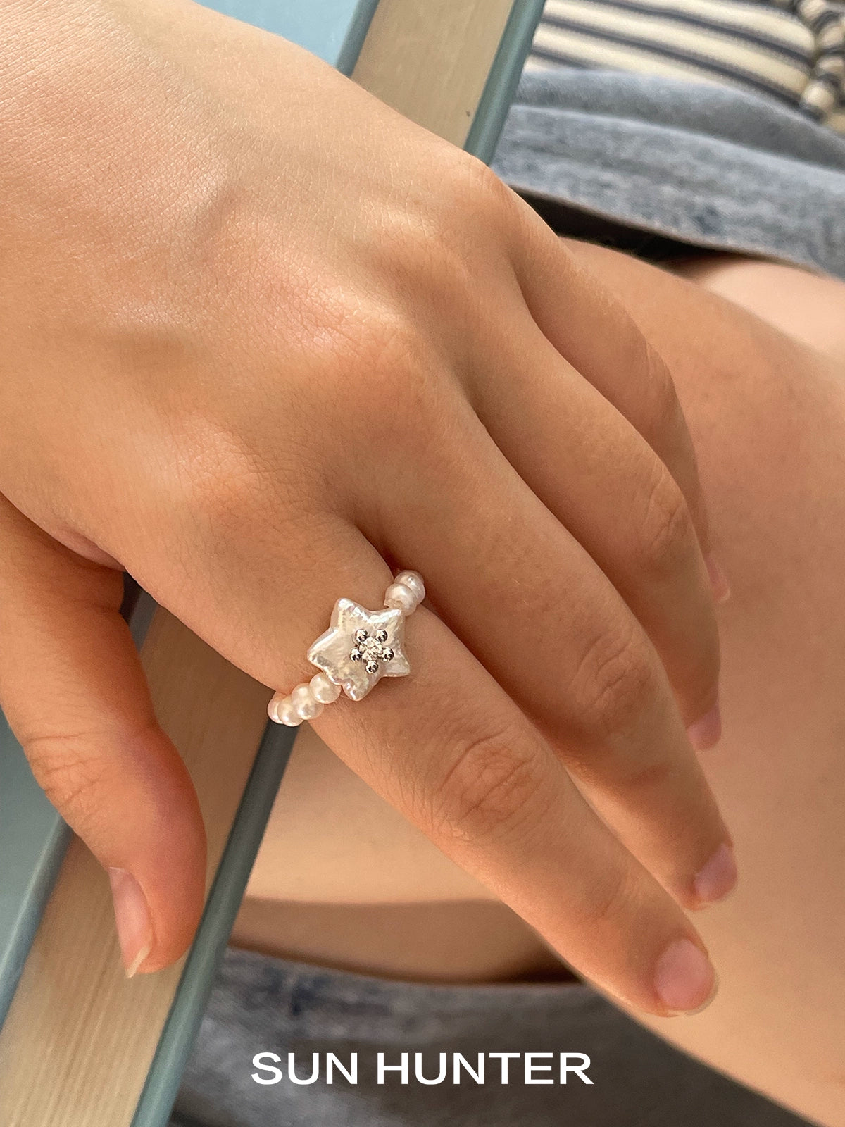 SUN HUNTER star pearl ring featuring a star design with a sparkling gem and pearl accents