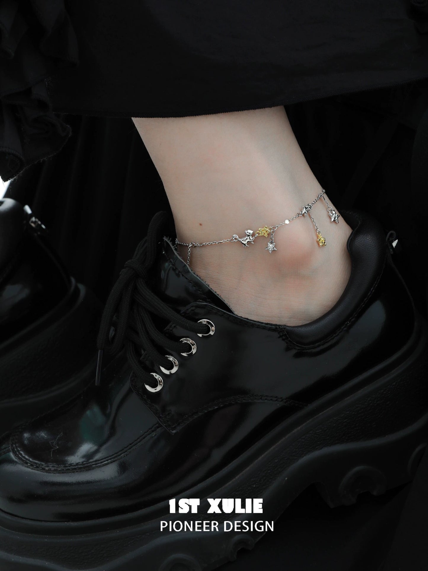Fashionable star picking cat silver anklet showcased on a stylish black platform shoe