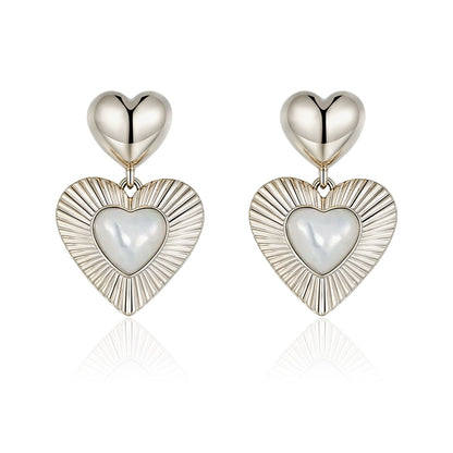 SUN HUNTER heart shaped statement earrings with polished silver and pearl details for a bold look