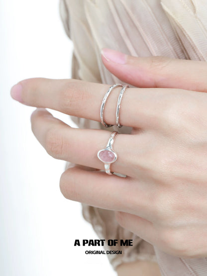 Elegant strawberry stone silver ring featured on a model's hand with delicate silver bands.