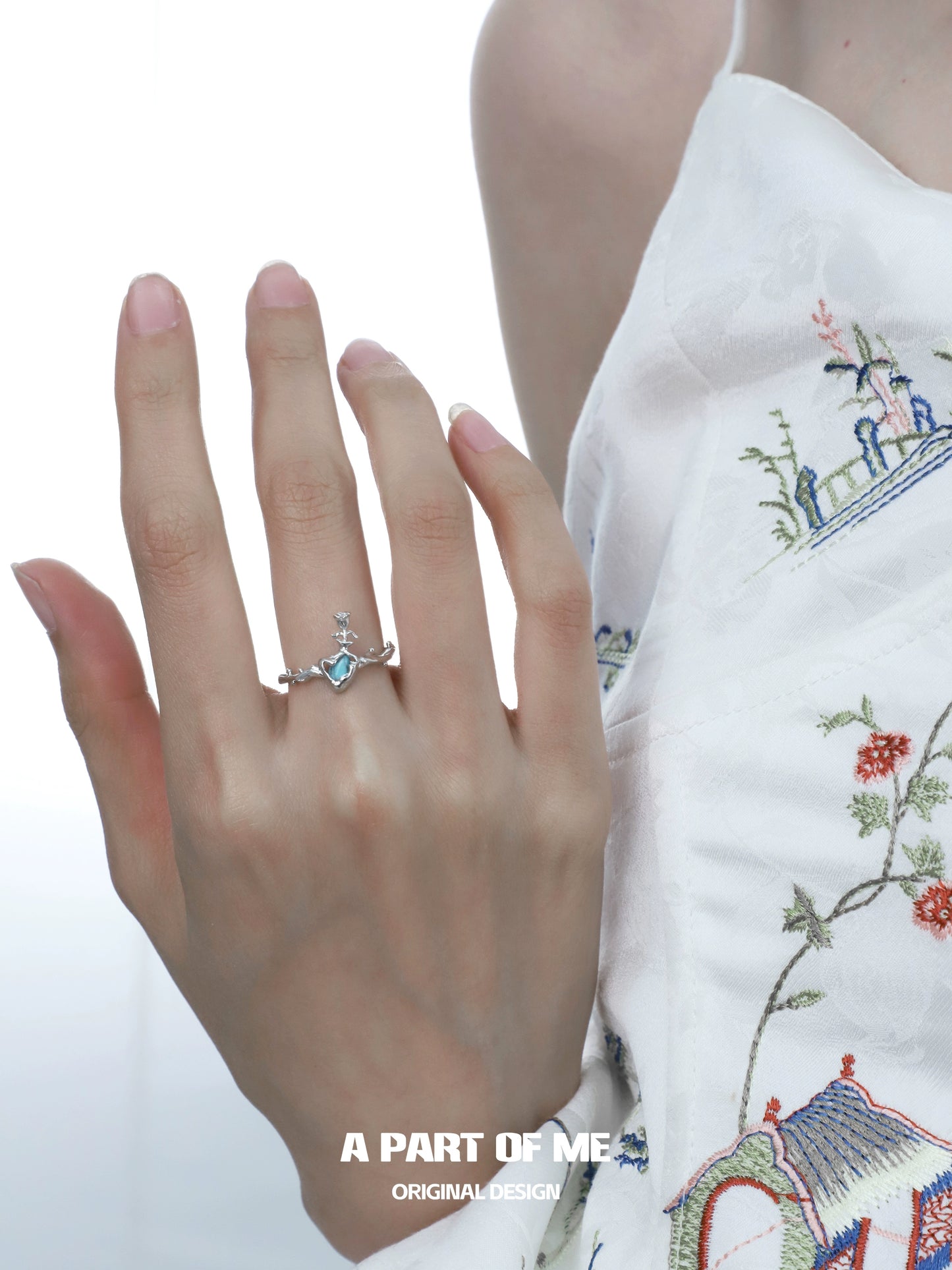 A PART OF ME summer rose ring in silver with a blue gemstone, elegantly worn on a model's hand