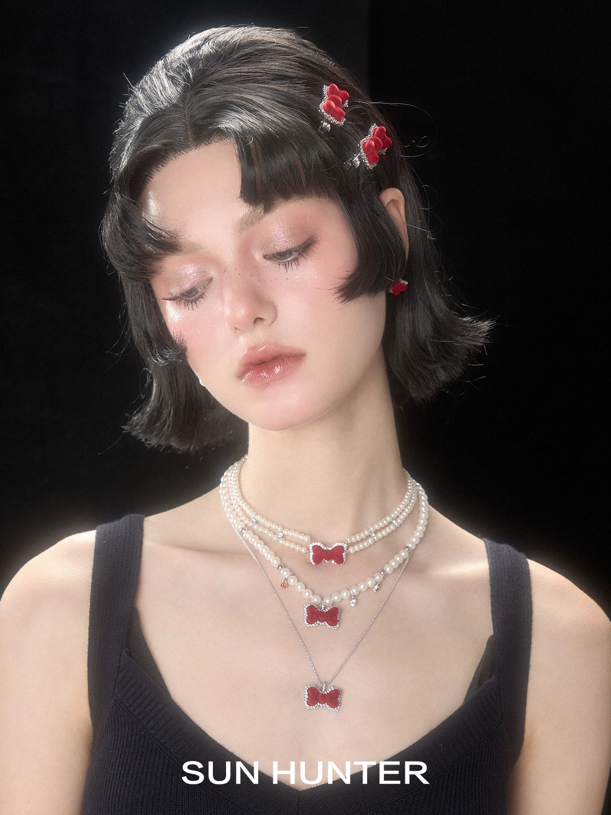 Elegant woman wearing a SUN HUNTER necklace with a velvet butterfly heart ring accentuating her style