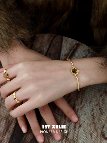 Elegant tiger eye shell silver bracelet designed by 1STXULIE, worn on a model's wrist