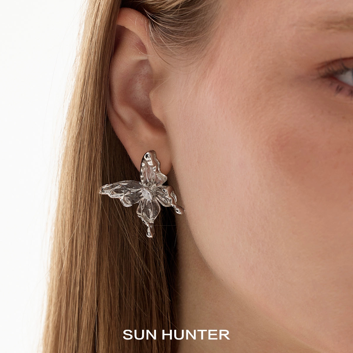 Elegant transparent butterfly earrings by SUN HUNTER, showcasing unique design and shimmering details