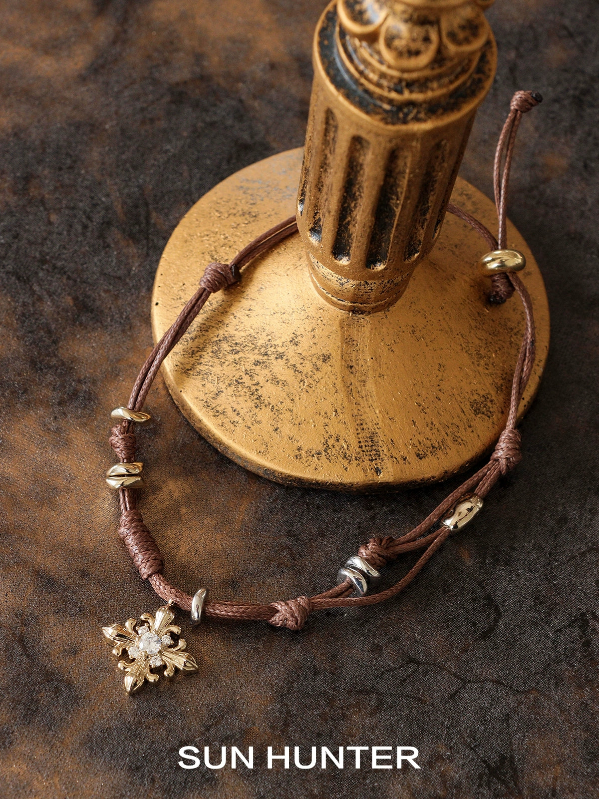 Twilight Iris braided bracelet by SUN HUNTER featuring a decorative charm and adjustable closure