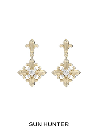 Unique floral drop earrings by SUN HUNTER featuring an elegant gold design with a sparkling center stone