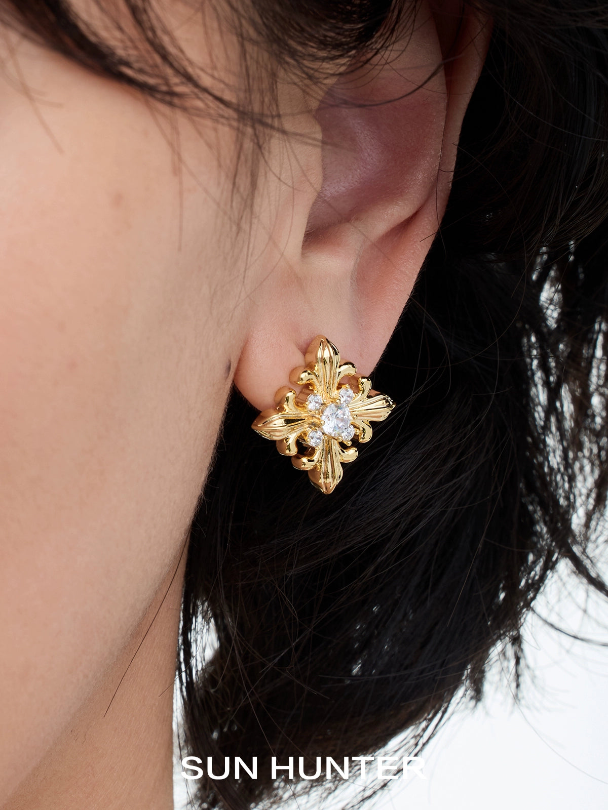 Unique square stud earrings by SUN HUNTER featuring intricate gold design and sparkling center stone
