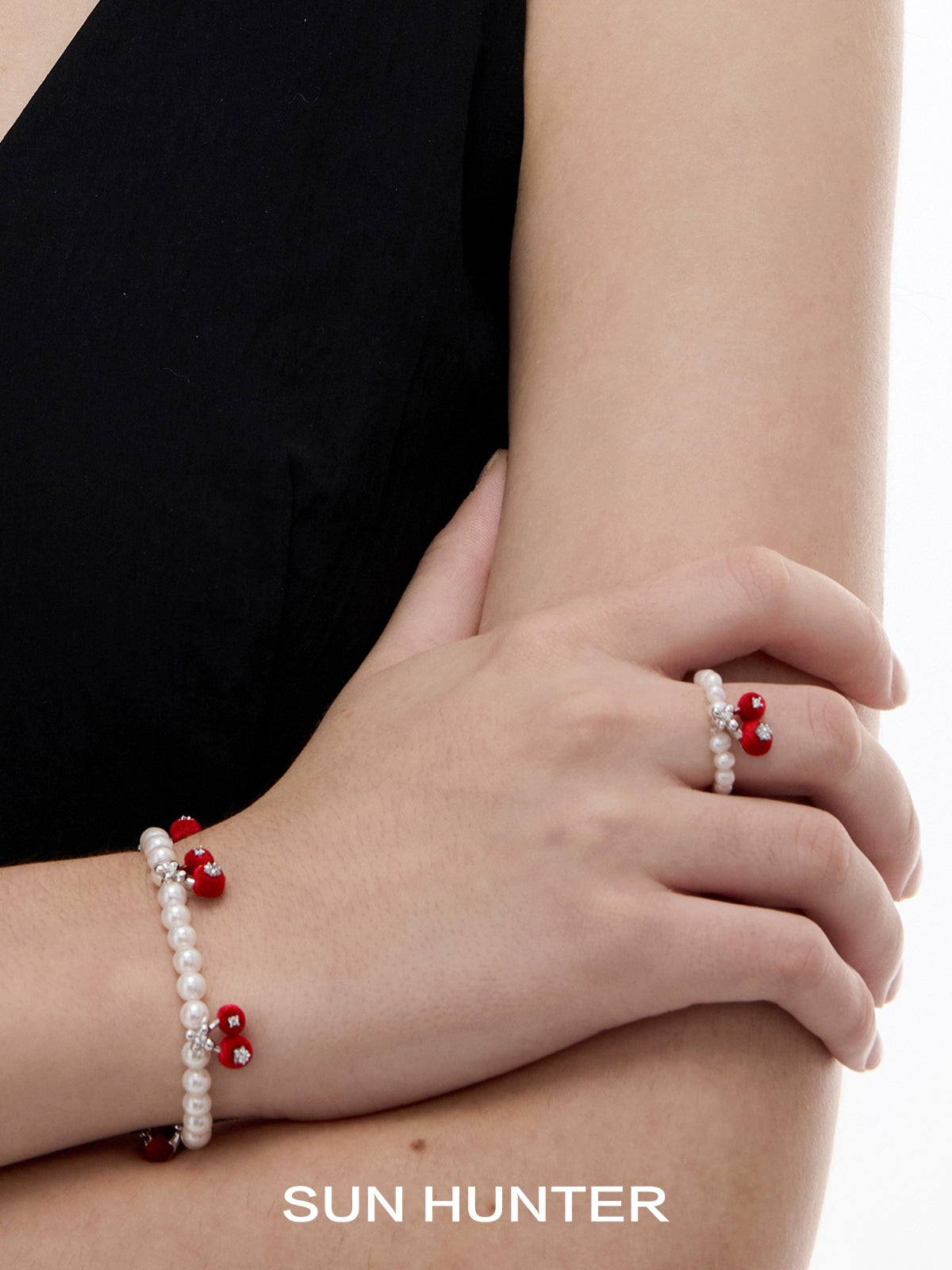 SUN HUNTER velvet cherry pearl ring paired with matching pearl bracelets on a model's hand