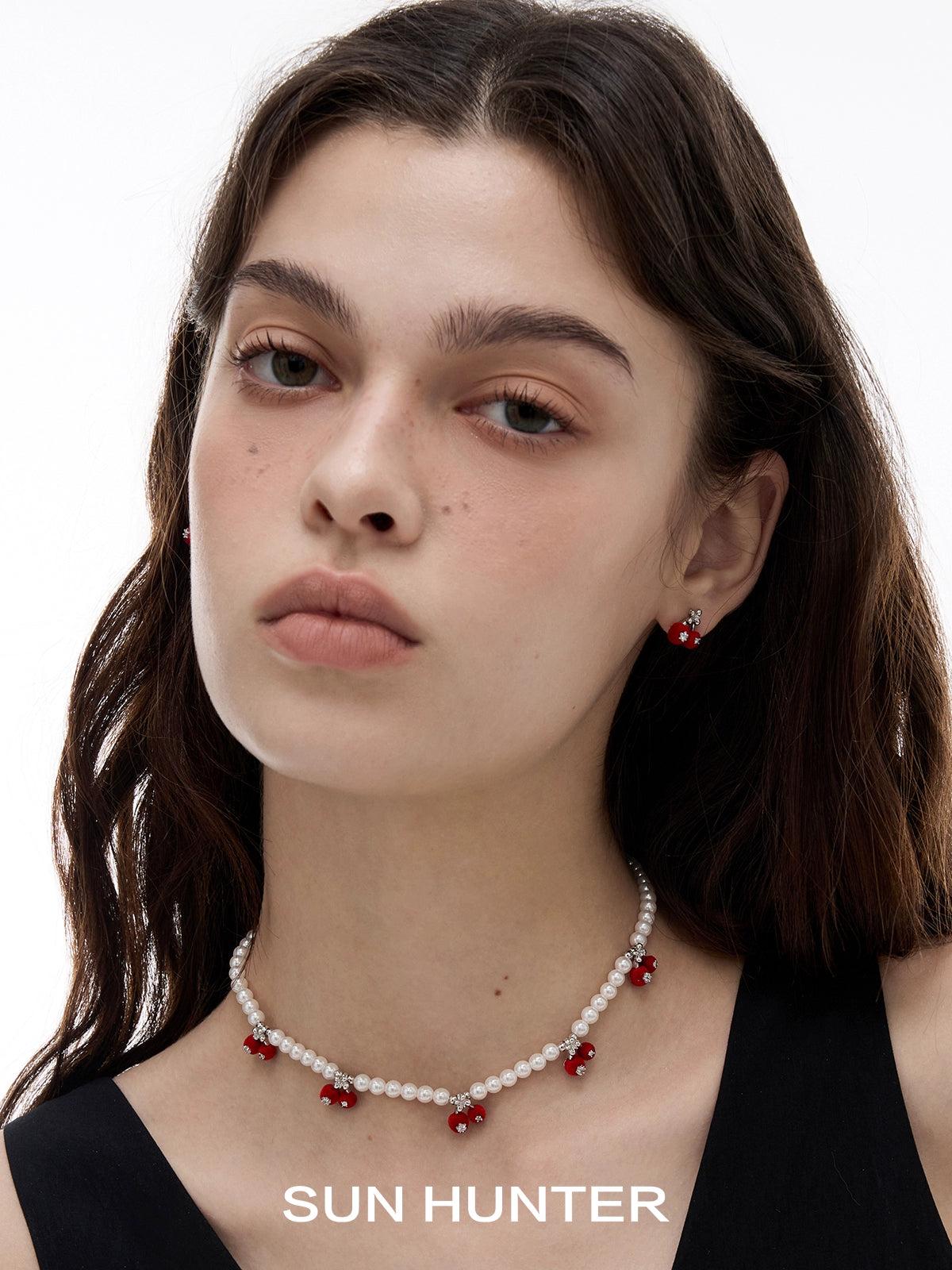 Elegant velvet cherry stud earrings showcased on model with matching pearl necklace