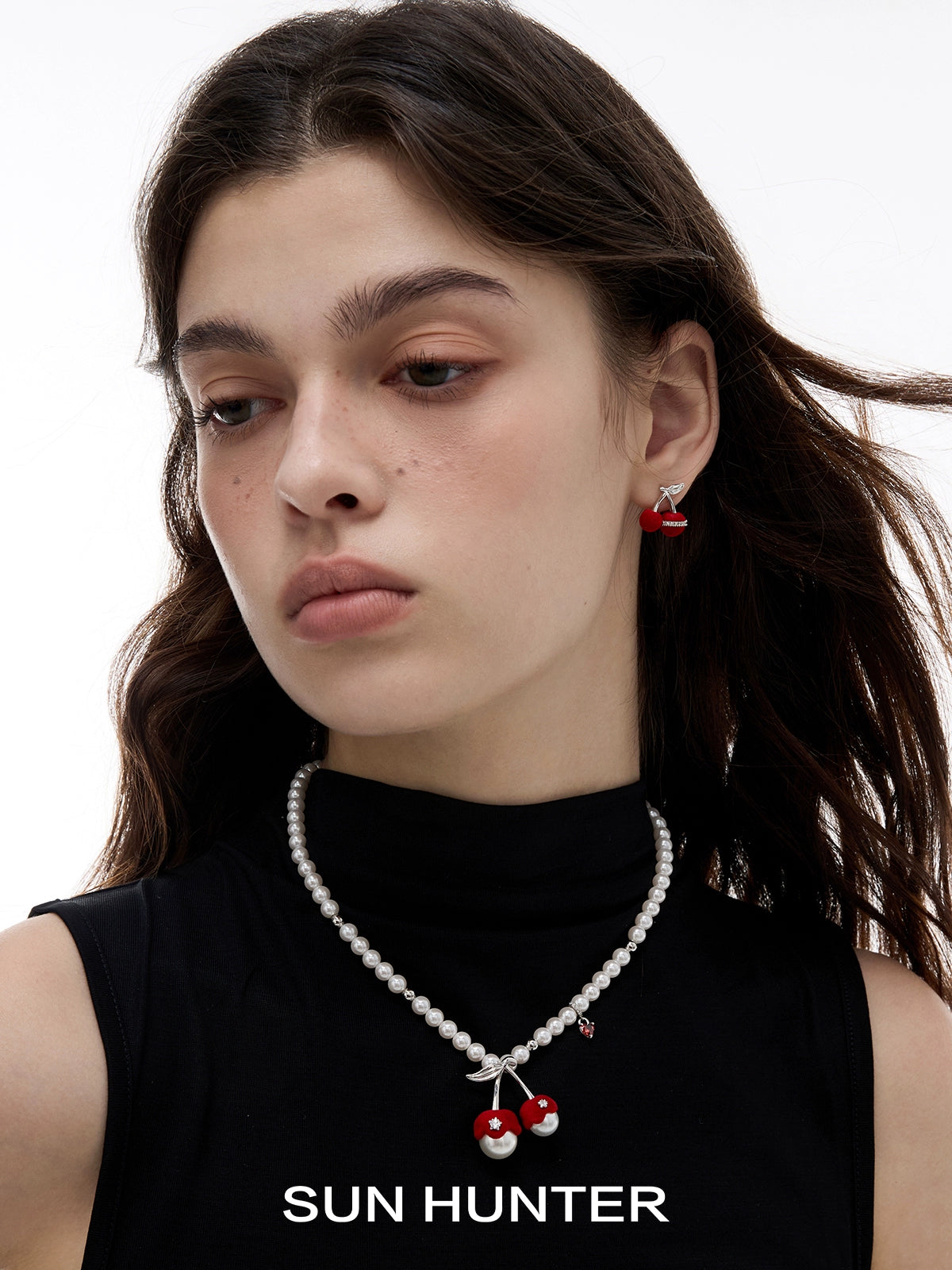 Model wearing velvet cherry stud earrings by SUN HUNTER with a pearl necklace for a stylish look