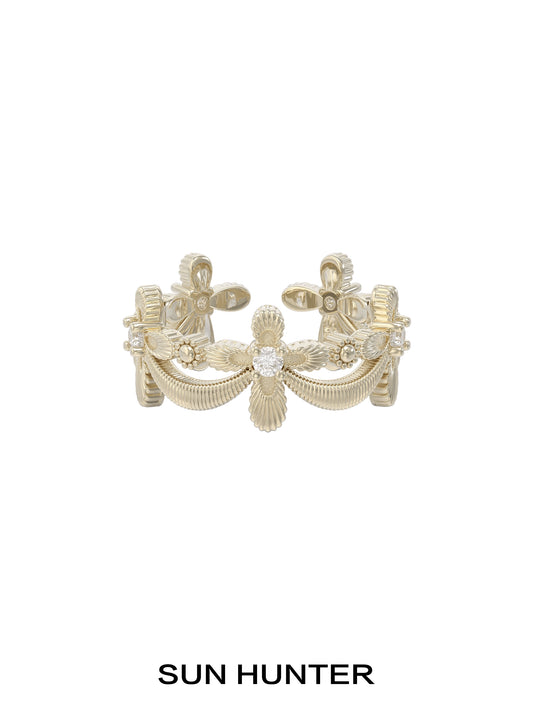 Elegant SUN HUNTER shimmer cross ring featuring intricate detailing and a sparkling center stone
