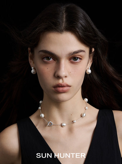 Model wearing vintage cocoon earrings paired with a matching pearl necklace from SUN HUNTER