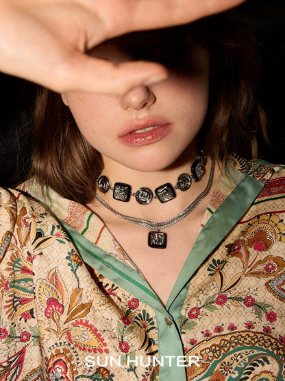 Model wearing vintage coin earrings and layered necklaces with intricate designs from SUN HUNTER