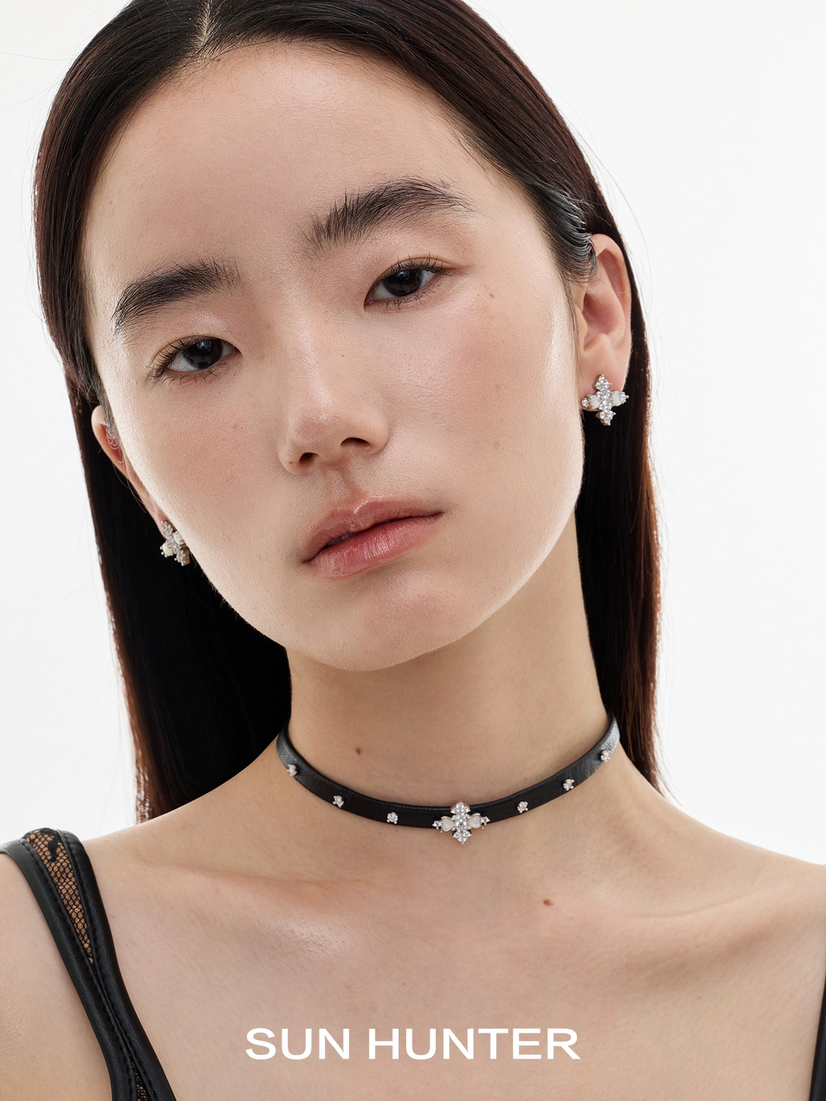 Model showcasing vintage cross earrings paired with a stylish black choker necklace