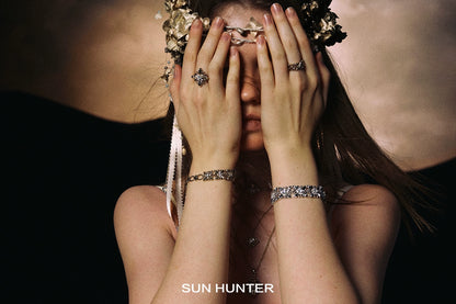 Model wearing vintage iris square ring and matching bracelets by SUN HUNTER in an artistic pose