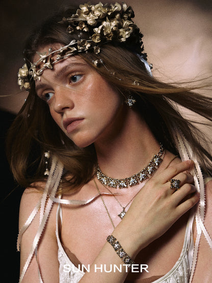 Model wearing vintage iris square ring along with matching jewelry and floral accessories