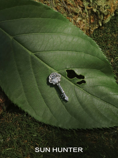 SUN HUNTER vintage lace key earrings displayed on a green leaf for a natural look