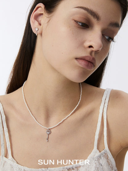 Elegant model showcasing vintage lace key earrings paired with a delicate necklace from SUN HUNTER