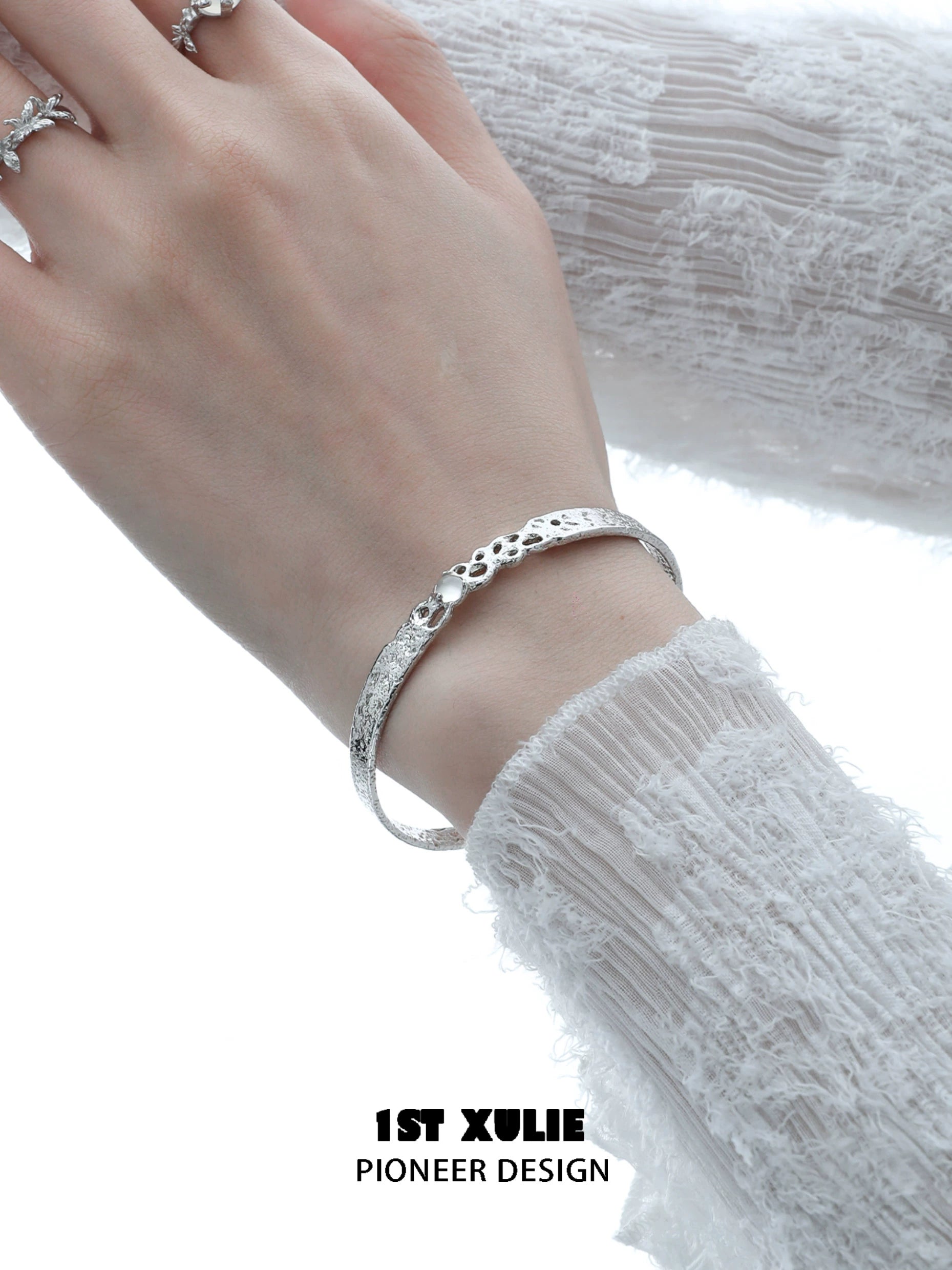 Elegant white agate bangle bracelet on a woman's wrist, featuring a textured design