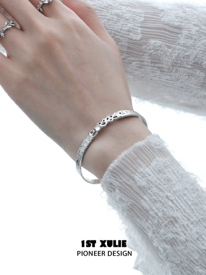 Elegant white agate bangle bracelet on a woman's wrist, featuring a textured design