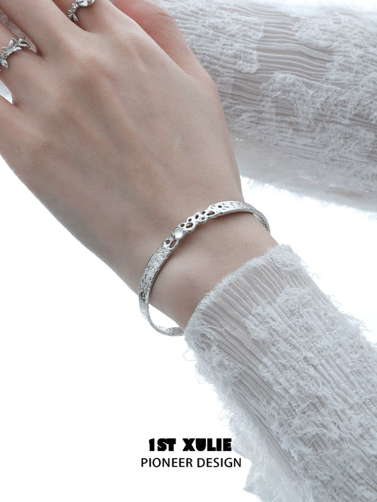 Elegant white agate bangle bracelet on a woman's wrist, featuring a textured design